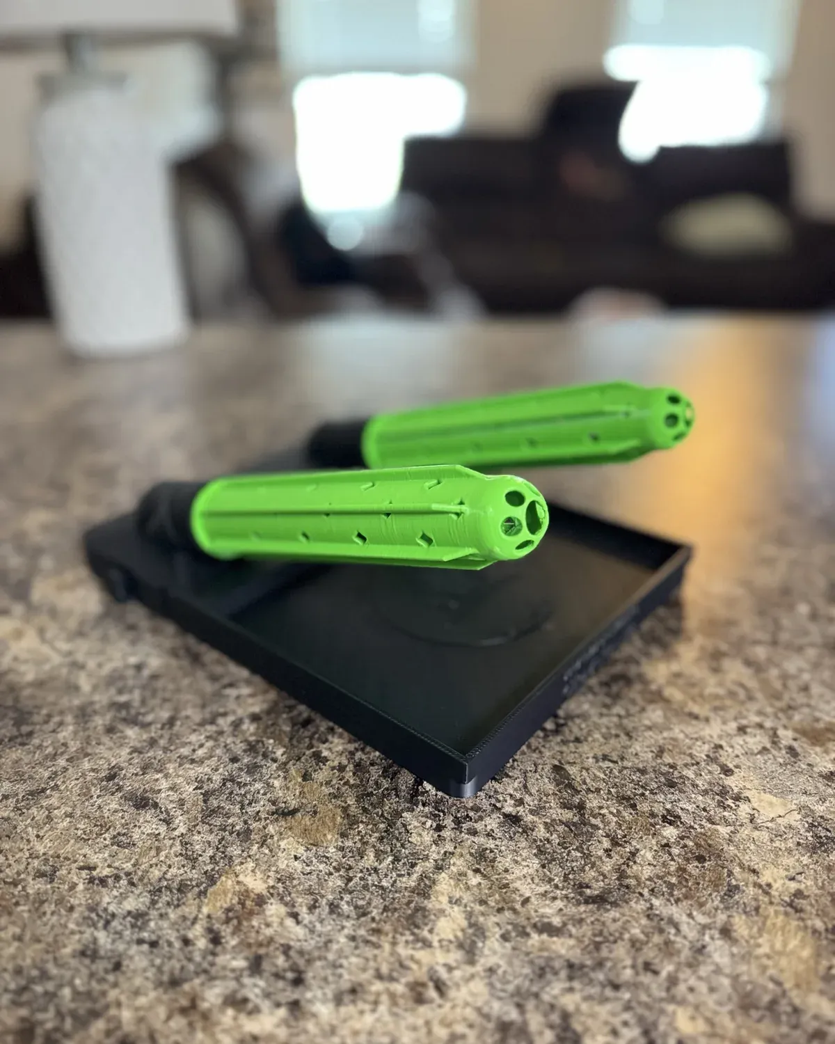 Black and safety green GloveDash units with perforated drying tubes on a counter